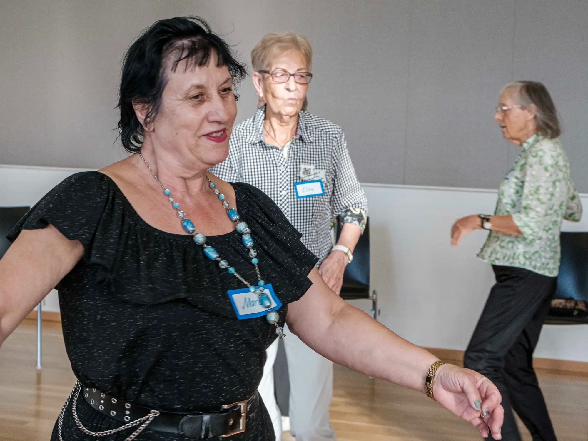 Drei ältere Frrauen bewegen sich in einem Raum.