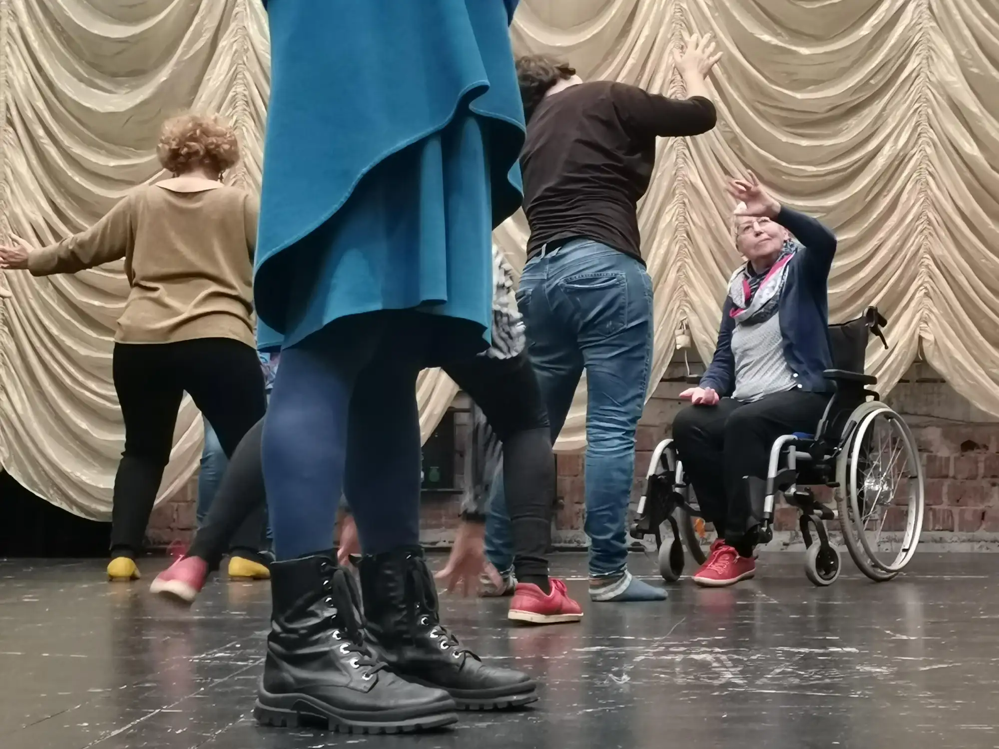 Eine Gruppe von Menschen tanzt auf einer Bühne.